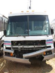 An RV with a bumper that been torn in half and a missing grill.